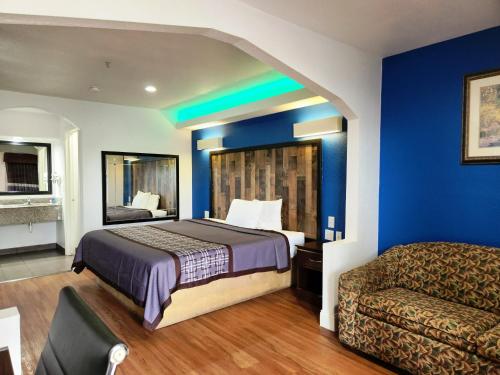 汤博尔Express Inn Tomball的酒店客房,配有床和沙发