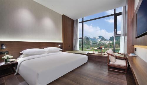桂林中心璞云酒店(桂林两江四湖象鼻山公园店)的一张大白色的床,位于一个设有大窗户的房间