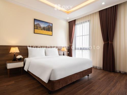 下龙湾Ha Long Essence Classic Hotel的卧室设有一张白色大床和一扇窗户。