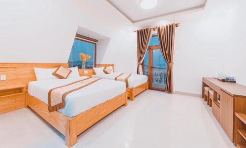大叻Hoàng Yến Villa Dalat的一间卧室配有两张床、一张桌子和一台电视。