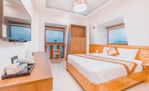 大叻Hoàng Yến Villa Dalat的一间卧室配有一张床和一张书桌及电视