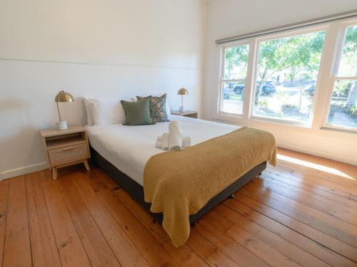 拜伦湾查理海滨别墅的一间卧室设有一张大床和一个大窗户