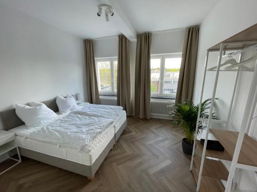 汉堡Airport Apartments for 4 - Kitchen - Parking with eCharging的一间卧室,里面装有床和植物