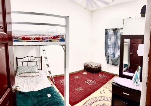 哥打丁宜Isyfaq Homestay 2 bedroom & 2 bathroom的一间卧室配有双层床和红色地毯。