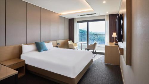 春川Chuncheon Eston Hotel的一间设有大床和窗户的酒店客房