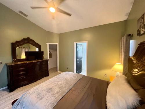 达文波特Grand Superior 4BR Pool House near Disney Parks的一间卧室配有一张大床和镜子