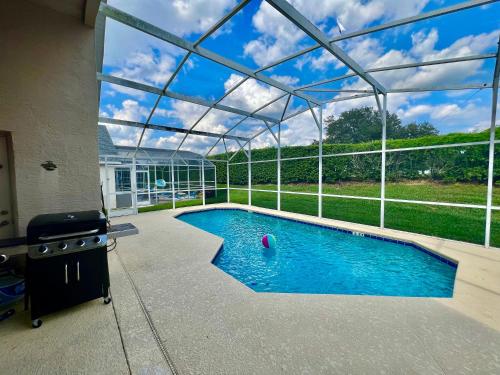 达文波特Grand Superior 4BR Pool House near Disney Parks的一座玻璃屋顶房子中的游泳池