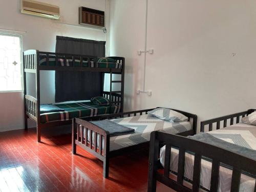 马六甲Travellers Diary Guesthouse的客房设有两张双层床和一扇窗户。