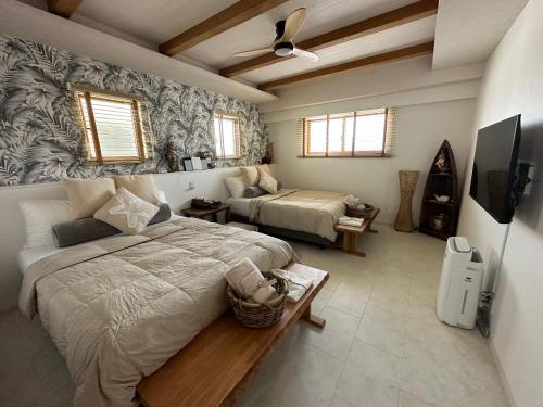 北谷町ResortHouse-KAPUKA的一间带两张床的卧室和一台电视