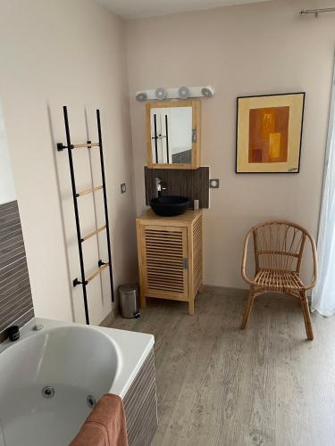 里摩日La Maison de l'Auzette的带浴缸、椅子和镜子的浴室