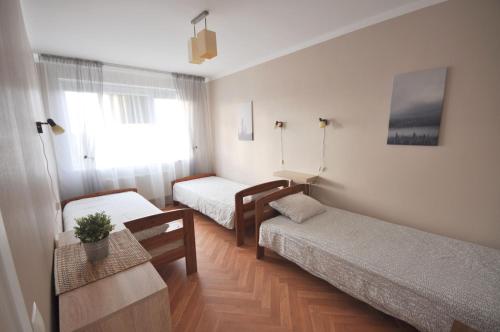 叶卡布皮尔斯Apartamenti Jēkabpilī的小房间设有两张床和一张桌子