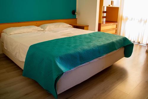 阿莱萨诺科利布瑞酒店的一张床上有绿毯的床