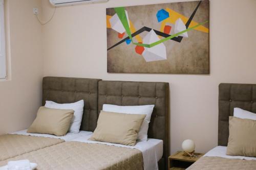 韦莱斯Cholakovi Apartments的墙上画画的房间里设有两张床