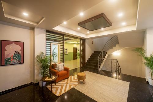 班加罗尔Olive Electronic City - by Embassy Group的一间带楼梯和椅子的客厅
