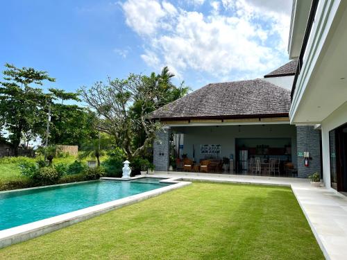 坎古Oshan Villas Bali的一个带游泳池和房子的后院
