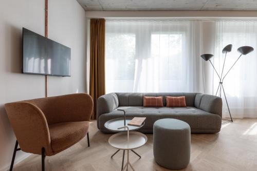 伯尔尼Alpenblick Bern - kind of a hotel的客厅配有沙发和两把椅子