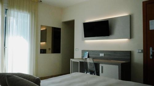 文蒂米利亚卡力酒店的酒店客房设有一张床和墙上的电视