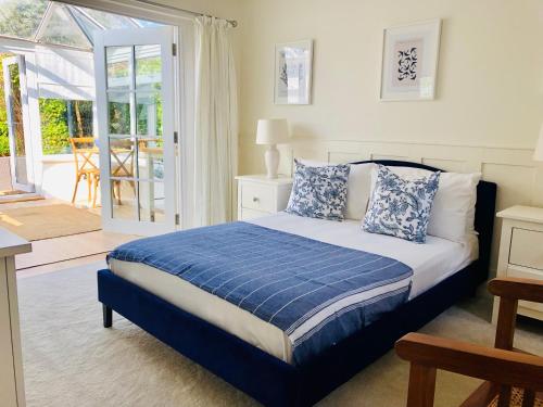 奇切斯特Secluded Spacious Garden Suite的一间卧室配有一张带蓝色和白色枕头的床