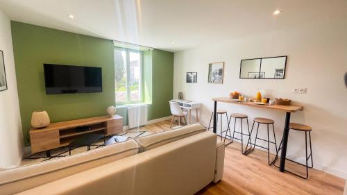 尼奥尔Le Vert’ueux - Appartement tout équipé à Niort的带沙发和电视的客厅以及酒吧。