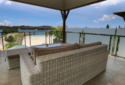 马埃岛JA Enchanted Waterfront Seychelles的带沙发的客厅,享有海滩美景