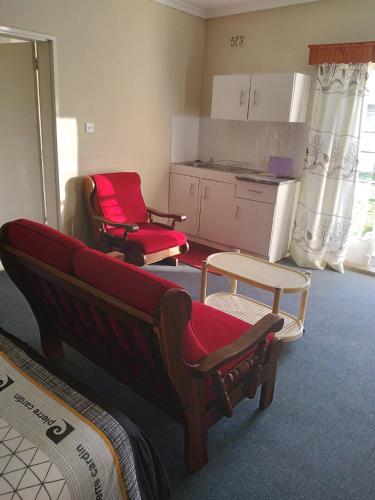 哈拉雷Neat guest suite with office corner - 2101的一间带两把椅子的客厅和一间厨房
