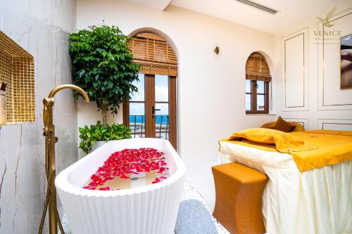 富国Roma Hotel Phu Quoc - Free Hon Thom Island Waterpark Cable Car的浴室配有装满红花的浴缸。