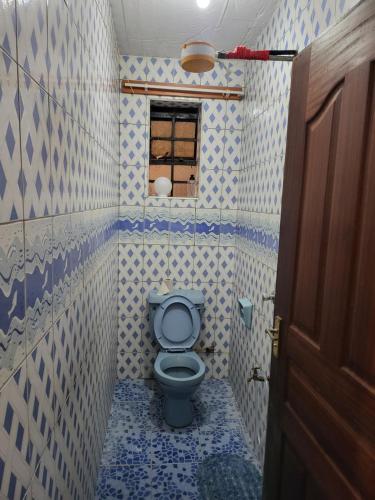 纳库鲁G&G Homes Ngala Nakuru的浴室设有蓝色和白色瓷砖,配有卫生间