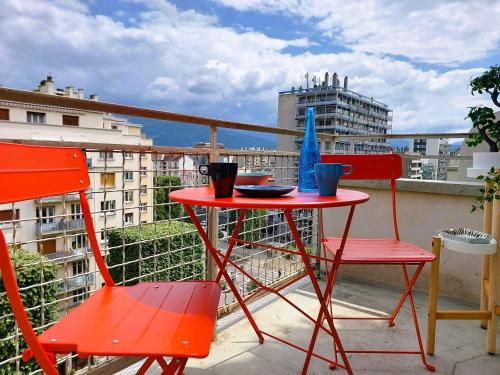 格勒诺布尔Lumineux 2 Chambres avec Garage privé - Tram à 1 min的阳台上配有一张红色的桌子和两把椅子