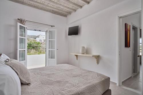米克诺斯城Philippi Villa的一间白色卧室,配有床和电视