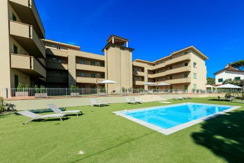 蒂勒尼亚Residence San Francesco的一座带游泳池和一些草坪椅的大型建筑