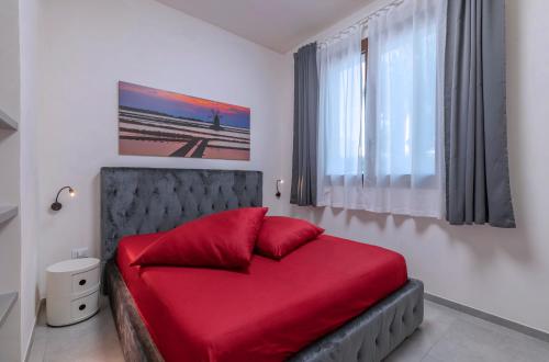马尔萨拉Casa B, Room 3 - Palm Kite Paradise的一间卧室配有一张红色的床和窗户