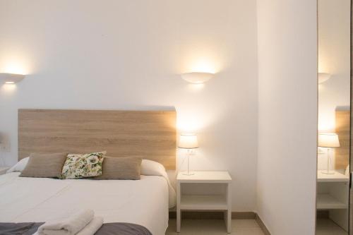桑坦德利亚湾Grupoandria Aparthotel Club Andria的一间卧室配有一张床、两张桌子和两盏灯。