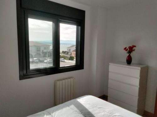 艾利亚德亚罗萨PISO COLLAZO的一间卧室设有窗户、一张床和一个梳妆台