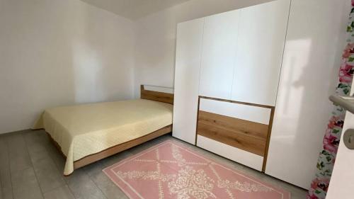 瓦尔纳Lola seaview guest house. Уютный Домик в Варне的一间小卧室,配有一张床和粉红色的地毯