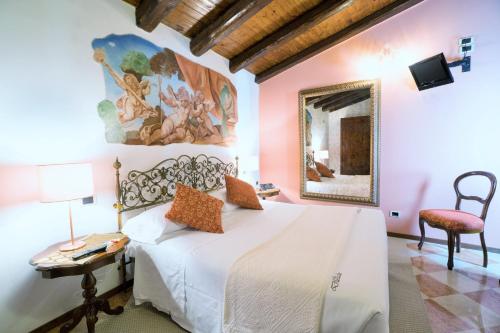 多洛里斯特朗特公爵别墅酒店 的一间卧室配有一张床、一张桌子和一面镜子