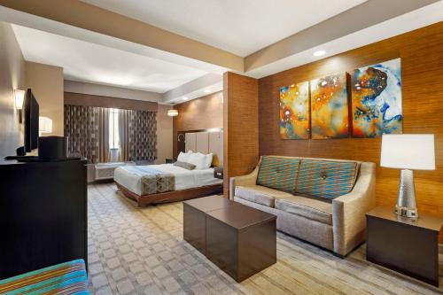 肯代尔Best Western Plus Miami Executive Airport Hotel and Suites的酒店客房,配有床和沙发