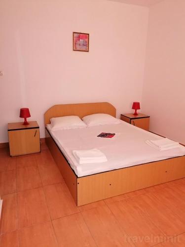 南埃福列Vila Albatros的一间卧室配有一张床、两个床头柜和两盏灯。