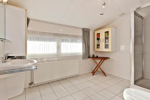 SonDe Keizersmantel的白色的浴室设有水槽和淋浴。