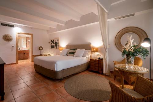 哈维亚Hotel Ritual de Terra & SPA的卧室配有一张床和一张桌子及椅子