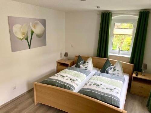 卡劳特格瑞斯赫Ferienwohnung "Am Kirchsteig"的一间卧室配有一张带绿色窗帘的床和窗户。