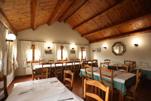 LamianaHotel de Montaña Lamiana的用餐室设有桌椅和木制天花板
