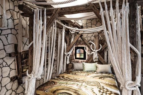 RamsauNaturerlebnis Suite - Nationalpark的卧室配有一张石墙天蓬床