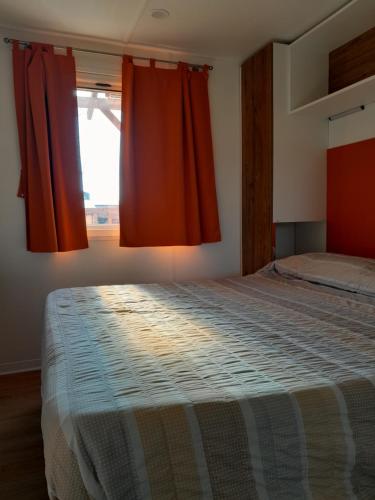 阿菲Agricampeggio Le Corniole的一间卧室配有一张带红色窗帘的大床