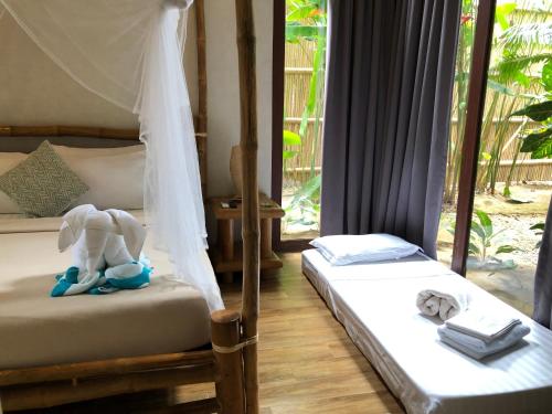 爱妮岛布科海滩度假村的一间卧室设有两张床,上面有大象。