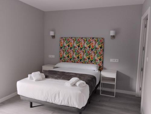 坎加斯-德奥尼斯Finca El Rabil的一间卧室设有两张床和一个色彩缤纷的床头板