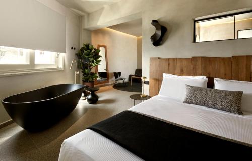 菲罗斯特法尼Damigos Caldera World的一间卧室设有一张大床和一个浴缸