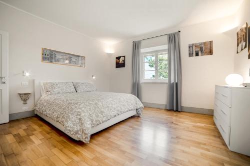皮恩扎Il Nido的白色的卧室设有床和窗户