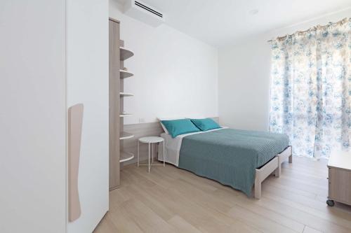 吉诺萨滨海Appartamento Vitalba by BarbarHouse的白色的卧室设有床和窗户