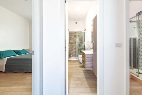 吉诺萨滨海Appartamento Vitalba by BarbarHouse的一间卧室配有一张床,玻璃门通向浴室