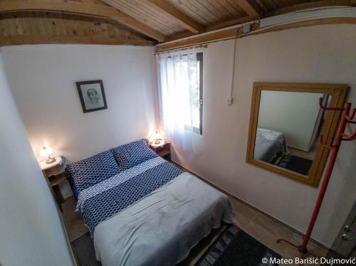 里斯卡Apartman Kos的一间小卧室,配有一张床和镜子